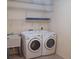 Bright laundry room, washer, dryer, and ample shelving at 8590 Se 157Th Pl, Summerfield, FL 34491