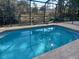 A refreshing pool with a screen enclosure offers privacy and a tranquil outdoor space at 8590 Se 157Th Pl, Summerfield, FL 34491