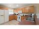 Functional kitchen with wooden cabinets, white appliances, and tiled backsplash at 1039 Sandhill St, Groveland, FL 34736