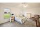 Well-lit bedroom with a floral-patterned bedspread and view to the outdoors at 5206 Fantasy Way, Leesburg, FL 34748