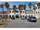 Exterior view of a commercial building showcasing Mediterranean-style architecture with palm trees and ample parking at 5206 Fantasy Way, Leesburg, FL 34748