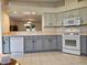 Spacious kitchen with gray cabinets, tile floors and modern white appliances at 5206 Fantasy Way, Leesburg, FL 34748