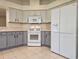 Updated kitchen features gray cabinets, tile floors, and white appliances at 5206 Fantasy Way, Leesburg, FL 34748