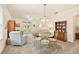 Open-concept living room featuring a glass-top dining table and chairs and ample natural light at 5206 Fantasy Way, Leesburg, FL 34748