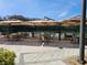 Outdoor patio with tables and umbrellas, adjacent to the community tennis court at 5206 Fantasy Way, Leesburg, FL 34748