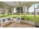 Inviting screened porch with comfortable wicker furniture and a view of the lush backyard at 5206 Fantasy Way, Leesburg, FL 34748