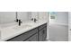 Modern bathroom featuring a double vanity with white countertop and gray cabinetry adjacent to carpeted bedroom at 6224 Trailblaze Bnd, Saint Cloud, FL 34771