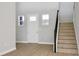 Entryway with light wood floors and staircase with iron railing at 6224 Trailblaze Bnd, Saint Cloud, FL 34771