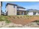 Two-story home with neutral siding, blue trim, solar panels, and landscaping in the backyard at 6224 Trailblaze Bnd, Saint Cloud, FL 34771