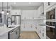 Bright, modern kitchen featuring white cabinets, stainless steel appliances, and an island with a sink at 6224 Trailblaze Bnd, Saint Cloud, FL 34771