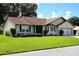 Well maintained house featuring a brown roof, neutral siding and manicured lawn at 6410 Tildon Ct, Leesburg, FL 34748