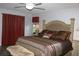 King-size bed in spacious main bedroom with wood-look floors at 6410 Tildon Ct, Leesburg, FL 34748