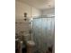 Bathroom with a shower featuring a starfish-themed curtain, toilet, and towel racks at 104 Turtle Run, Umatilla, FL 32784