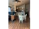 Cozy dining area with wood floors, white table and chairs, seamlessly connecting to the kitchen at 104 Turtle Run, Umatilla, FL 32784