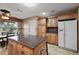 Well-lit kitchen features an island, tile flooring, and stainless steel refrigerator at 1401 Valparaiso St, The Villages, FL 32162