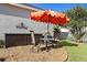 Outdoor patio features a table, seating, umbrella, and decorative rock area; a cozy spot for relaxation at 1622 Carrera Dr, The Villages, FL 32159