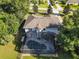 An aerial view of a home with a screened pool, manicured lawn and mature trees at 24126 Plymouth Hollow Cir, Sorrento, FL 32776