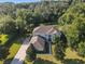 A beautiful home is surrounded by a lush forest and large, well-maintained yard in an overhead view at 24126 Plymouth Hollow Cir, Sorrento, FL 32776