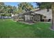 Spacious backyard featuring a screened-in lanai with comfortable seating for outdoor relaxation and entertainment at 24126 Plymouth Hollow Cir, Sorrento, FL 32776