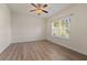 Bedroom with wood-look flooring, a ceiling fan, and a window at 24126 Plymouth Hollow Cir, Sorrento, FL 32776