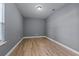 Minimalist bedroom with neutral-toned walls, wood flooring, and natural light from a window with blinds at 24126 Plymouth Hollow Cir, Sorrento, FL 32776