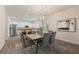Dining area with modern lighting and wood table seamlessly connects to the open kitchen at 24126 Plymouth Hollow Cir, Sorrento, FL 32776