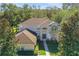Two-story home showcases mature landscaping, a brick driveway, and a well-maintained exterior at 24126 Plymouth Hollow Cir, Sorrento, FL 32776