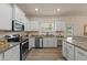 Bright kitchen features white cabinets, granite countertops, and stainless steel appliances at 24126 Plymouth Hollow Cir, Sorrento, FL 32776