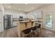 Open kitchen boasts white cabinets, stainless steel appliances, and a breakfast bar at 24126 Plymouth Hollow Cir, Sorrento, FL 32776