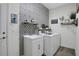 Stylish laundry room features patterned wallpaper, modern appliances, and ample storage solutions at 24126 Plymouth Hollow Cir, Sorrento, FL 32776