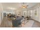 Open-concept living room features neutral decor, large windows, and a view of the adjacent kitchen at 24126 Plymouth Hollow Cir, Sorrento, FL 32776