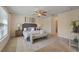 Spacious main bedroom featuring a ceiling fan, neutral walls, and a comfortable king-sized bed with bench at 24126 Plymouth Hollow Cir, Sorrento, FL 32776