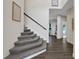 Carpeted staircase with wooden handrail leads to the upper level of the home at 24126 Plymouth Hollow Cir, Sorrento, FL 32776