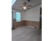 Bright living room featuring a ceiling fan and wood-look flooring, plus paneled walls with ample natural light at 2871 Myakka River Rd, Tavares, FL 32778