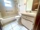 Neutral-toned bathroom with a tub and shower combination next to a single sink vanity with marble countertop at 1415 Harnden W Rd, Port Orange, FL 32129