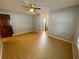 The bedroom features grey walls, light wood floors, and a ceiling fan for comfort at 1415 Harnden W Rd, Port Orange, FL 32129