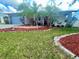Landscaped front yard with palm trees and decorative mulching, enhancing the home's curb appeal at 1415 Harnden W Rd, Port Orange, FL 32129