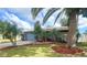 Charming one-story home with well-maintained lawn and lush landscaping, including palm trees at 1415 Harnden W Rd, Port Orange, FL 32129