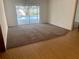 The spacious carpeted living room features sliding door access to the backyard pool area at 1415 Harnden W Rd, Port Orange, FL 32129