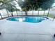 Outdoor blue pool is surrounded by a spacious patio, inside a screened enclosure at 1415 Harnden W Rd, Port Orange, FL 32129