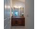 Bathroom with wood vanity, mirror, and neutral tile flooring at 1750 Kingfisher Ct, The Villages, FL 32162