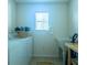 Bright laundry room, washer, dryer, utility sink, and storage at 1750 Kingfisher Ct, The Villages, FL 32162