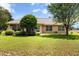 House with a large backyard and lush landscaping at 209 Shannon Ln, Lady Lake, FL 32159