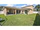 Wide view of expansive back yard with patio and green lawn at 4947 Ne 124Th Rd, Oxford, FL 34484