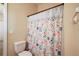 Bathroom with floral shower curtain and white toilet at 4947 Ne 124Th Rd, Oxford, FL 34484