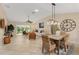 Bright dining room features a wood table and wicker chairs, adjacent to the living room at 410 Ainsworth Cir, The Villages, FL 32162
