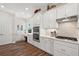 Modern kitchen with white cabinets, stainless steel appliances, and hardwood floors at 8732 Providence Ct, Mount Dora, FL 32757