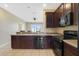 Kitchen with dark wood cabinets and modern appliances at 34416 Tuscany Ave, Sorrento, FL 32776