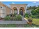 Inviting front entrance with arched doorways, decorative columns, and lush landscaping for curb appeal at 13129 Coldwater Loop, Clermont, FL 34711
