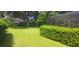 Manicured backyard with lush lawn and tidy hedges leading to a screened-in pool area at 2602 Tryon Pl, Windermere, FL 34786